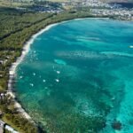 an aerial view of a beach with boats in the water
