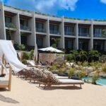 a hotel with a pool and lounge chairs