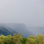 a view of a mountain range with trees in the foreground