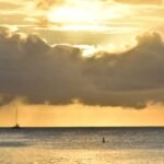 Sunset bathes the sea and clouds in golden light.