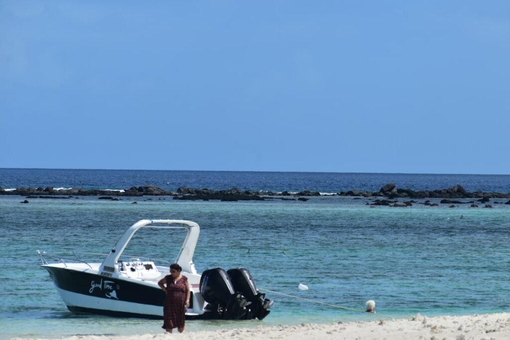 A man standing on a beach next to a boat