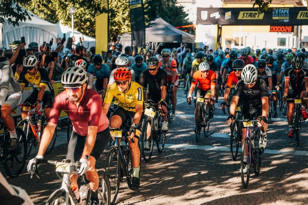 Cyclists race past cheering spectators at an event.