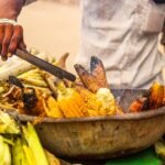 a person cutting a large pot of food