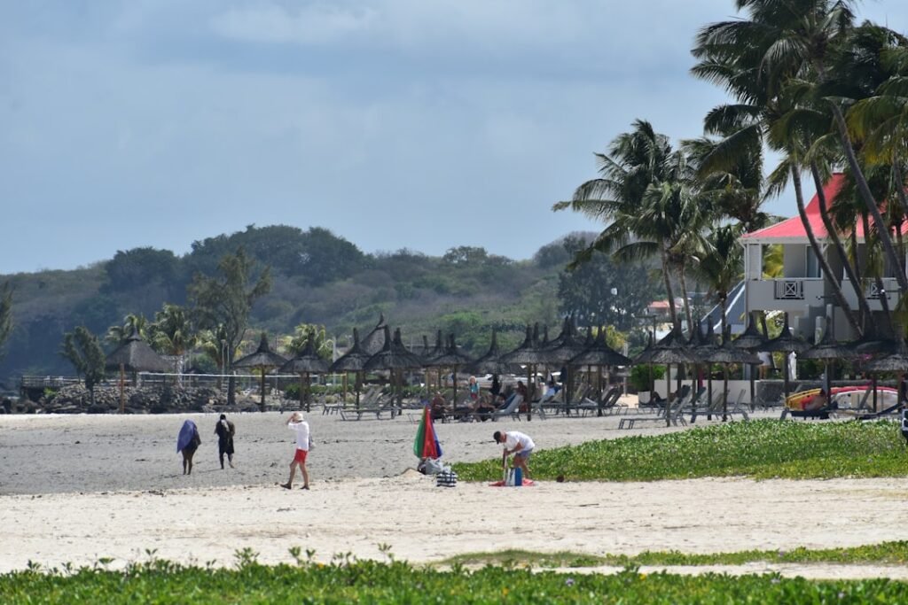 A group of people standing on top of a sandy beach