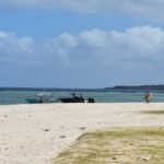 A group of people standing on top of a sandy beach