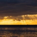 A large body of water under a cloudy sky