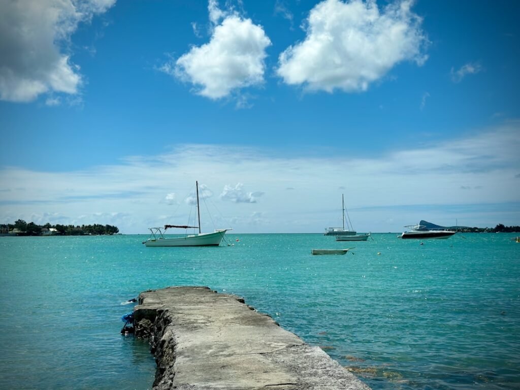 A pier with boats in the water and clouds in the sky