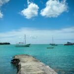 A pier with boats in the water and clouds in the sky