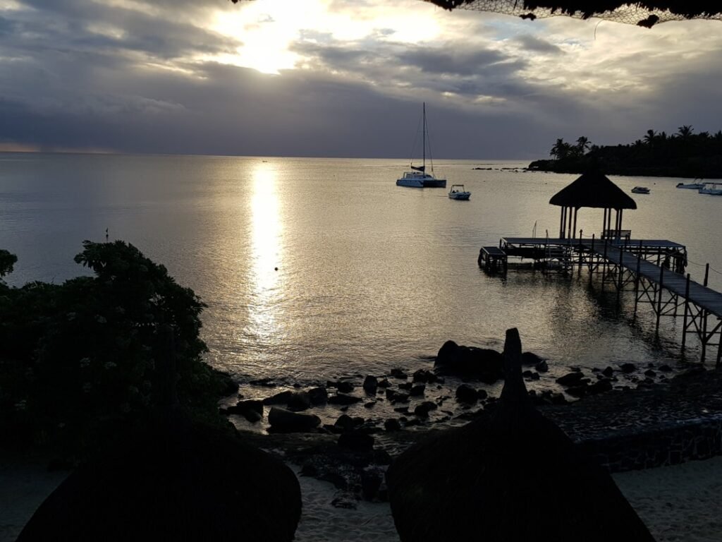 a dock on a beach with boats in the water