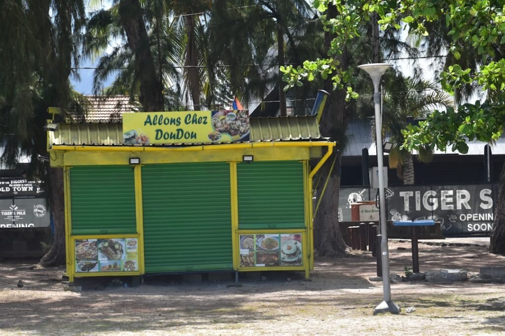 A yellow and green kiosk sitting on the side of a road