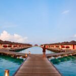 Overwater bungalows line a beautiful, turquoise sea.