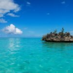 brown rock formation on blue sea under blue sky during daytime