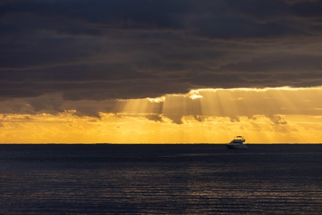 A boat in the ocean under a cloudy sky
