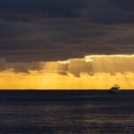 A boat in the ocean under a cloudy sky