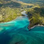 aerial photo of river between green mountains