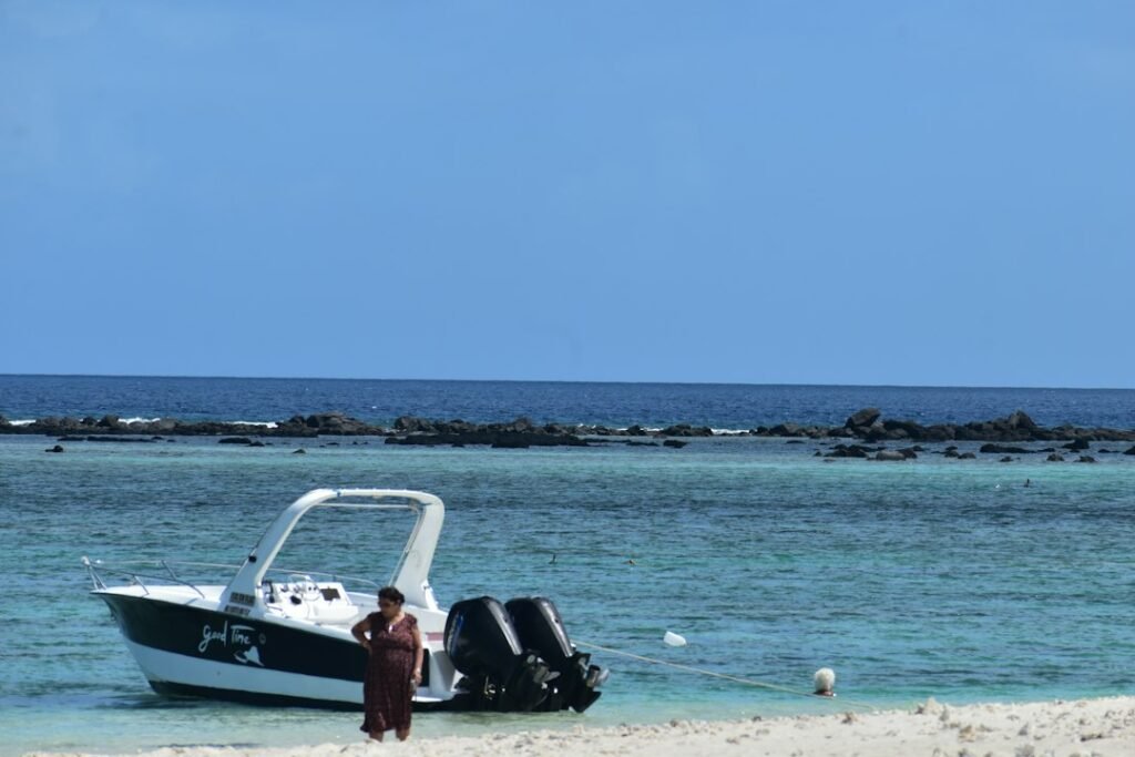 A man standing on a beach next to a boat