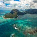 aerial photography of sea near mountain at daytime